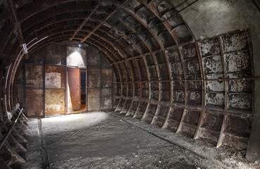 The end of an old rusty tunnel with an iron partition in an abandoned subway shaft.