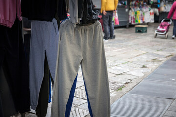 Selective blur on grey sweatpants, used for a gray tracksuit, for sale on an empty market. These pants and trousers are used for sports primarily, but usually as well for lounging. ..