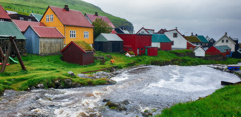 Picturesque view on village of Gjogv with typically colourful houses and a small river. Eysturoy...
