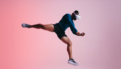 Fototapeta premium Sportsman jumping mid air with a VR headset
