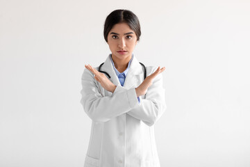Unhappy millennial cute hindu female medical worker in uniform say no, cross arms isolated on white...