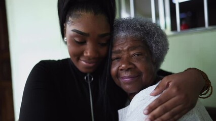 A teen granddaughter embracing grandmother a black girl embraces grandparent