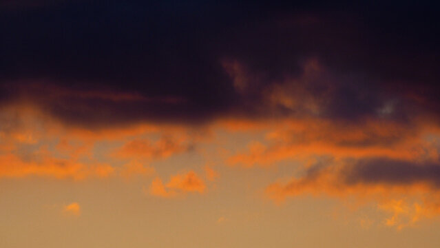 Crépuscule serein, entrecoupé par quelques passages nuageux, sous une lumière orangée © Anthony
