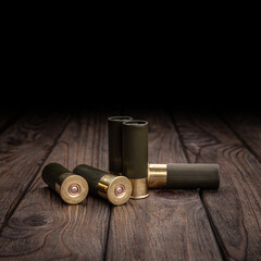 Shotgun cartridges on a brown wooden table. Ammunition for 12 gauge smoothbore weapons.
