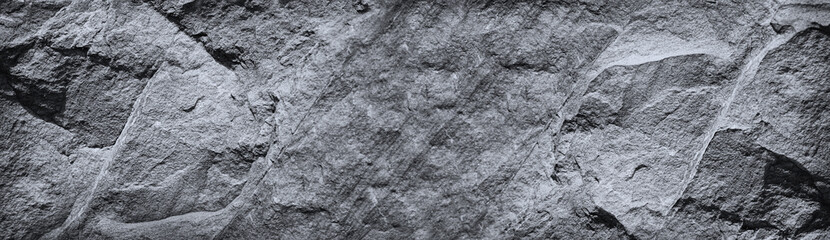 Black white rock texture. Mountain surface. Close-up. Gray granite stone background with copy space for design. Wide banner. Panoramic.