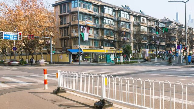 4k Timelapse video and footage of people and vehicles on a Chinese downtown city street or road close to a traffic light and apartments during daytime with bright blue skies on a sunny day panning out