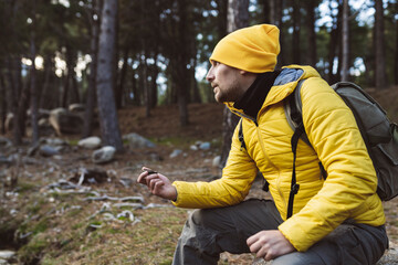 man in nature, consulting his compass in the forest