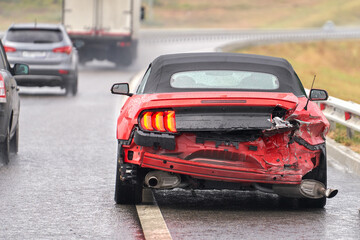  Accident on a slippery road in the rain. Sports car with a broken body close-up.