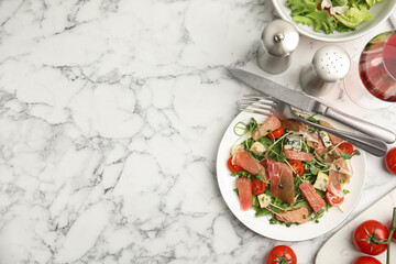 Delicious pomelo salad with prosciutto served on white marble table, flat lay. Space for text