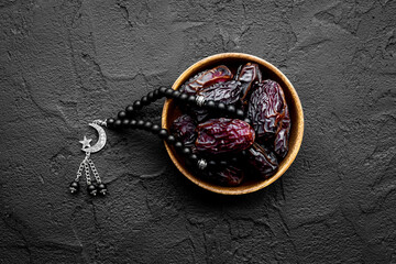 Ramadan concept. Black islamic rosary with crescent with dates fruits