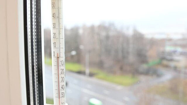 A view at window thermometer which indicates plus five degree celsius scale, spring thaw outdoor