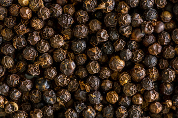 Black whole peppercorns peas close-up as a background. Spices of Cambodia. Seasoning for dishes. Additive ingredient for the preparation of delicious delicacies.