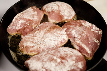 Chicken fillet frying in a pan.