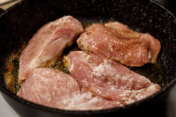 Turkey fillet frying in a pan.