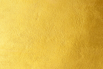Gold wall texture background. Yellow shiny gold foil paint on wall sheet with gloss light reflection