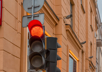 Red light on semaphore in the city with building background