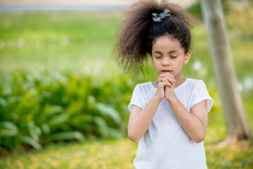 Fototapeta premium little girl praying happy relax in weekend holiday lifestyle park outdoor nature background.