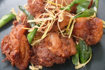 spicy fried chicken with chili and lemon leaf on dish