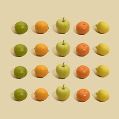 Pattern with limes, lemons, mandarins and apples on pastel yellow background.