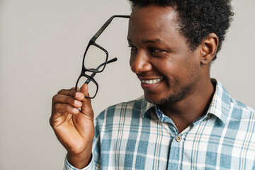 Black unshaven man smiling while posing with eyeglasses