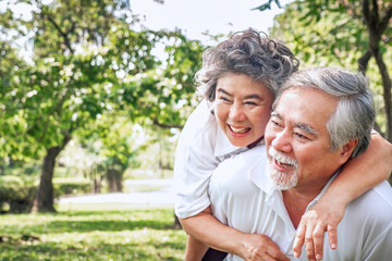 Naklejka premium relationship elderly couple health care in park, retirement old adult man and woman embracing in love hug and smile, People retirement lifestyle concept.