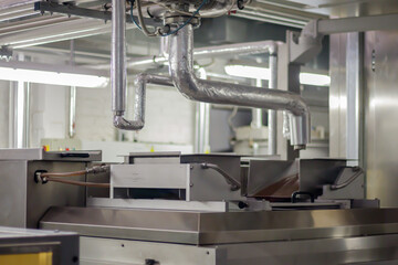 Line for the production of chocolate in an industrial factory. Automatic process in the production line of sweets. Images from the chocolate factory during production. Conveyor belt with sweets.