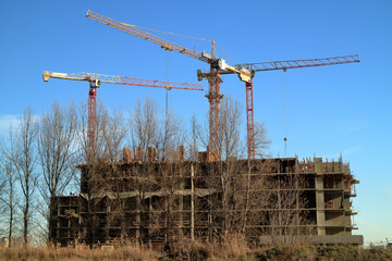 Tower cranes are working on the construction of a new house. Lifting crane.