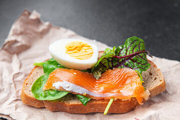 salmon sandwich smorrebrod egg, green salad mix, cereal bread toast seafood open sandwich fresh portion dietary healthy meal food snack on the table copy space food background rustic top view