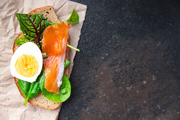 salmon sandwich smorrebrod egg, green salad mix, cereal bread toast seafood open sandwich fresh portion dietary healthy meal food snack on the table copy space food background rustic top view