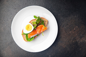salmon sandwich smorrebrod egg, green salad mix, cereal bread toast seafood open sandwich fresh portion dietary healthy meal food snack on the table copy space food background rustic top view