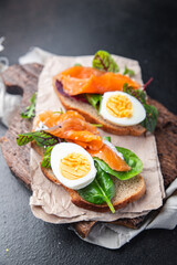 salmon sandwich smorrebrod egg, green salad mix, cereal bread toast seafood open sandwich fresh portion dietary healthy meal food snack on the table copy space food background rustic top view