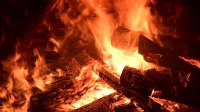 Close-up, flames from fire. Night bonfire, logs are on fire, sparks fly. 4k, ProRes