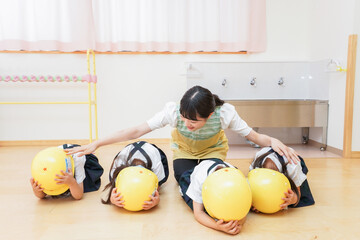 ヘルメットを被り避難する子供
