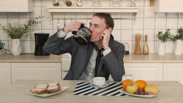 Haggard Entrepreneur Drinking Coffee in the Kitchen. Man Looks Disheveled and Untidy after Sleepless Night. Business, Lifestyle, Overworking Concept