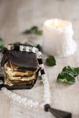 still life with old prayer book  candle and rosary on a table