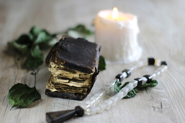 still life with old prayer book  candle and rosary on a table