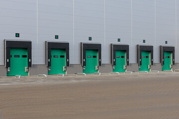 Row of loading docks with shutter doors at warehouse. Row gate.