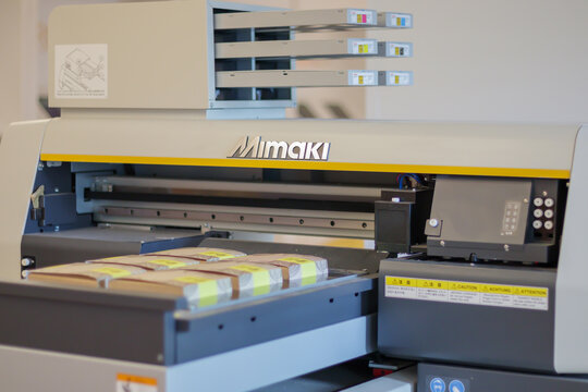 Printing machines in production. Mimaki logo on UV flatbed printer. Mimaki Engineering is a global industry manufacturer of large format inkjet printers. Ukraine, Kiev - February 09, 2022.