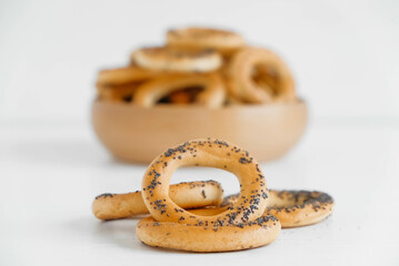 Dried bagels with poppy seeds in a wooden bowl on a white background