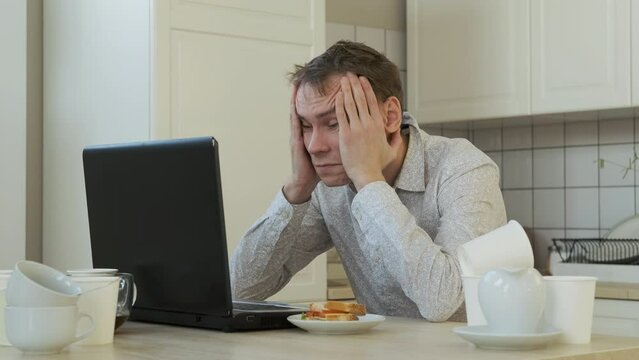 Tired Young Man Overwhelmed with Freelance Job Working on Laptop at Home. Slow Motion. Working Overtime and Remote Work Concept