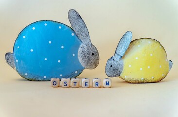 German word for easter, OSTERN, written with letter combinations, two metallic easter bunny rabbits...