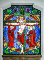 A stained glass window of christ on the cross in one of the ornate tombs at La Recoleta Cemetery in Buenos Aires