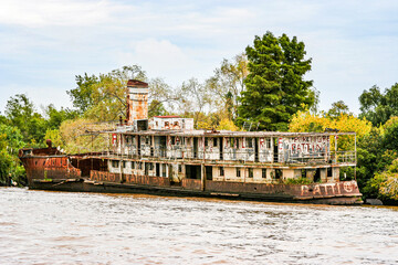 Fototapeta premium The long-abandonned rusting hulk of a river steamer lies in the Tigre delta near Buenos Aires in Argentina