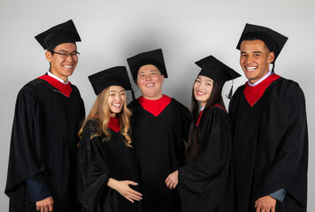 Group of graduate students friends pose together excitedly laughing