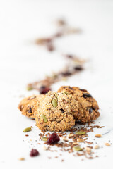 A small pile of trail mix cookies with a trail of the mix blurred out in behind.