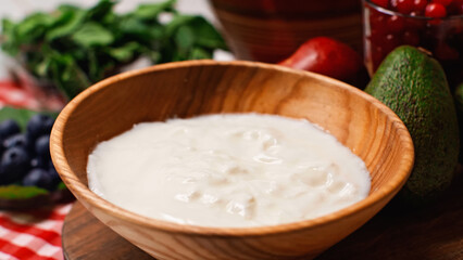 close up of fresh and tasty yogurt in wooden bowl