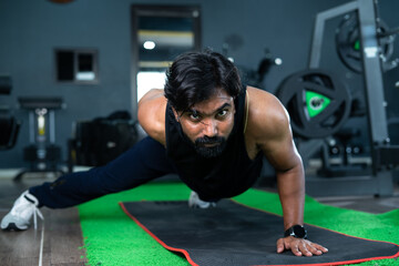 Young man doing one hand push ups at gym - concept of bodybuilding,hardworking, motivation and...