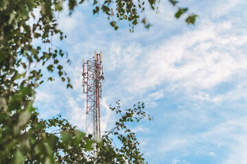 Obraz premium Cell tower against a blue sky with clouds.