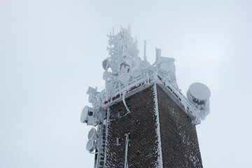 Telecommunication GSM internet data scaffolding antenna on top of the mountain in a winter freezing landscape