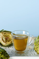 Artichoke tea glass cup. Raw artichoke vegetables with herbal beverage.